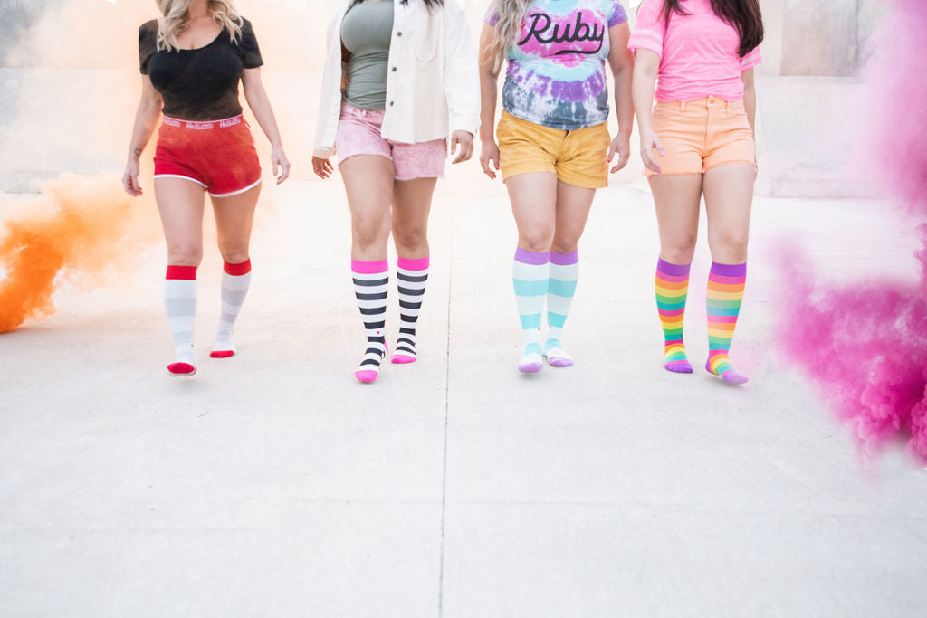compression socks on women walking through colorful smoke