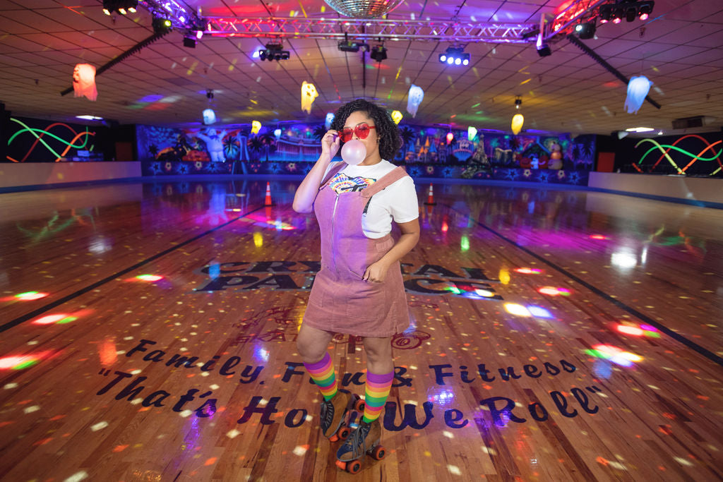 rainbow compression socks worn by a beautiful woman in a skating rink