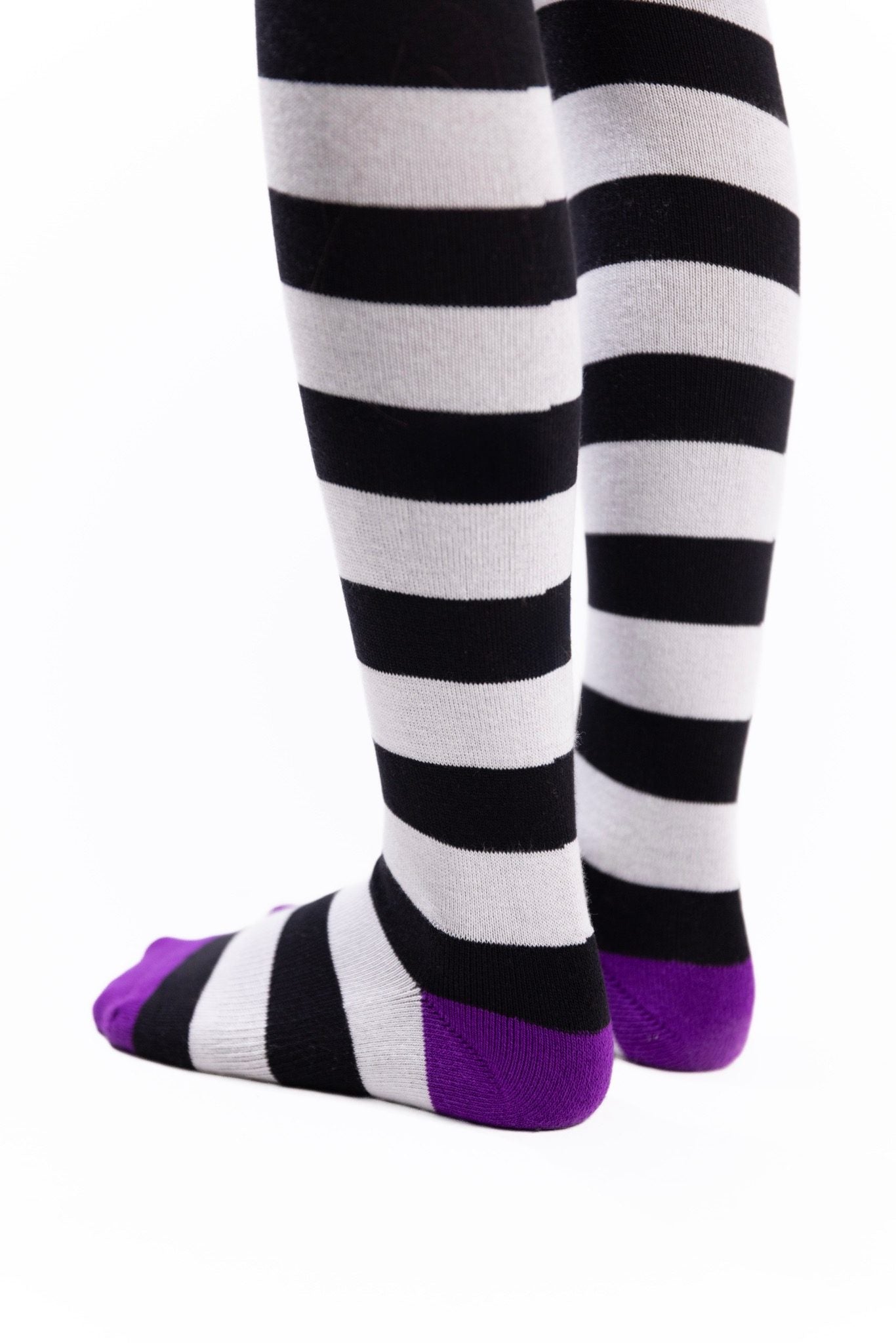 Black-and-white striped thigh-high socks with bright purple toes and heels.