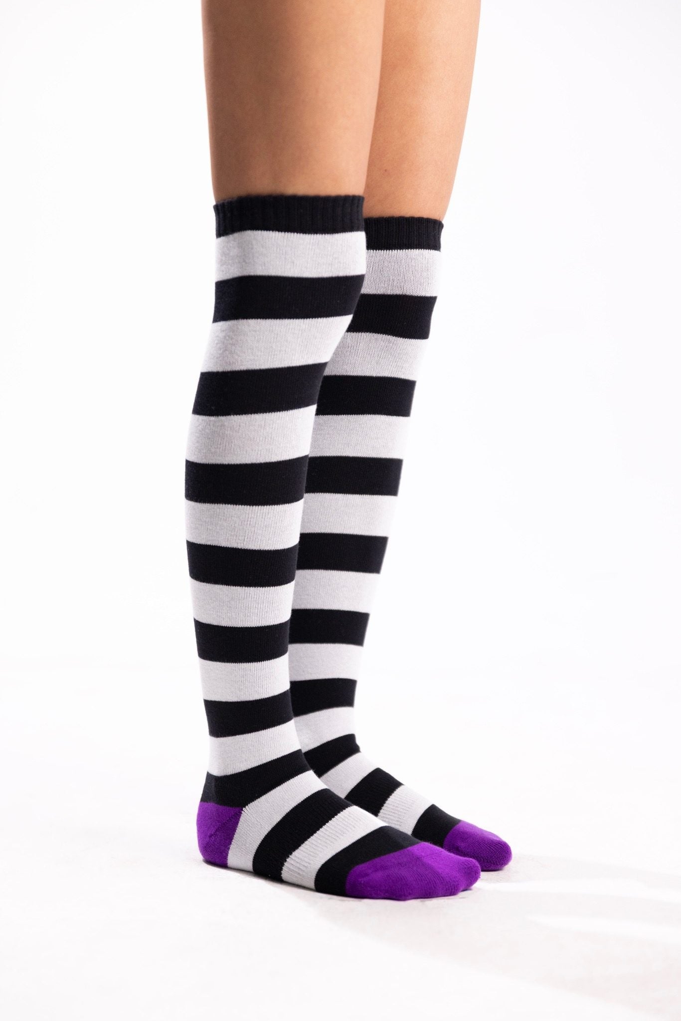 Black-and-white striped thigh-high socks with bright purple toes and heels.
