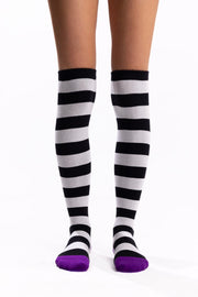 Black-and-white striped thigh-high socks with bright purple toes and heels.