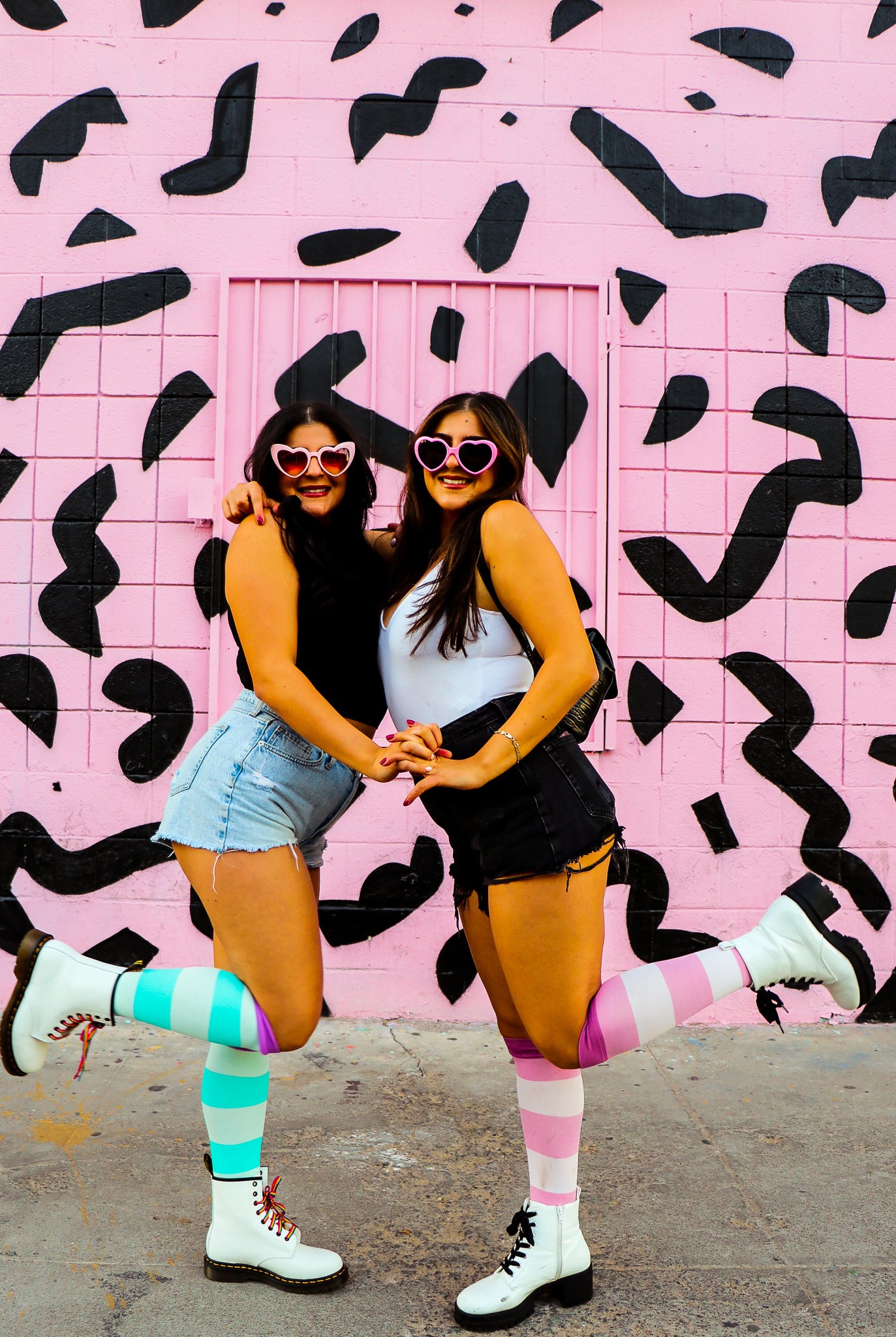 compression socks in pink aqua and lavender purple shown on two beautiful women in front of a pink wall with black accents and a shopping cart