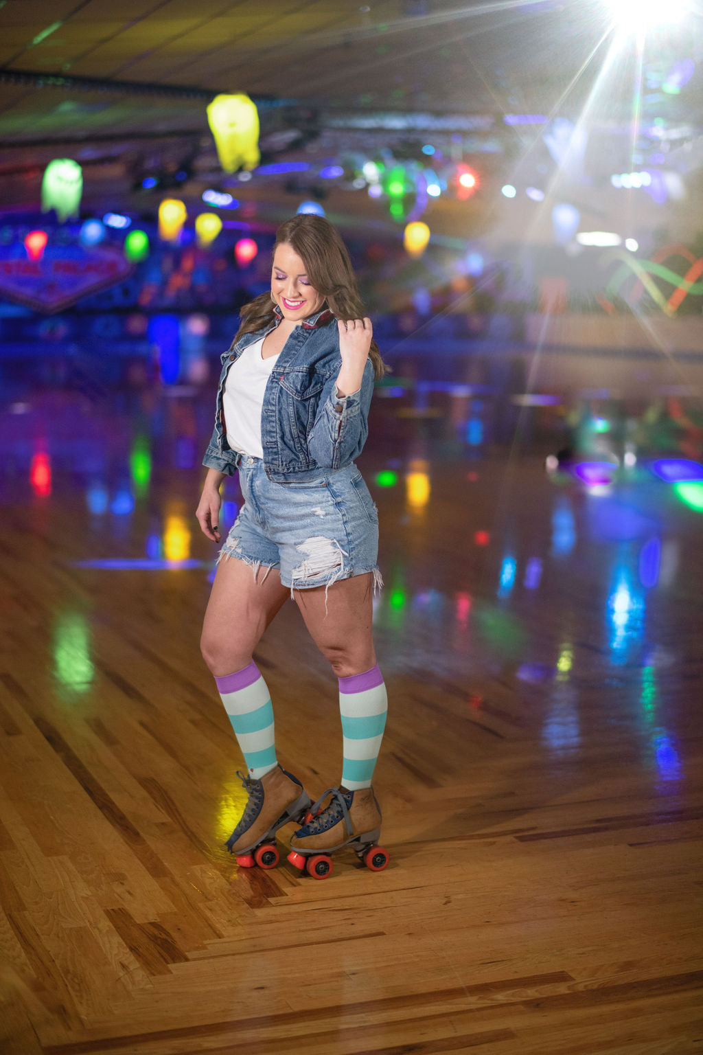 compression socks with aqua stripes and lavender purple accents on a beautiful woman in a roller rink
