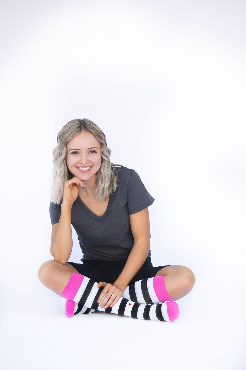 compression socks in black and white stripes with hot pink accents on the legs of a beautiful blonde woman