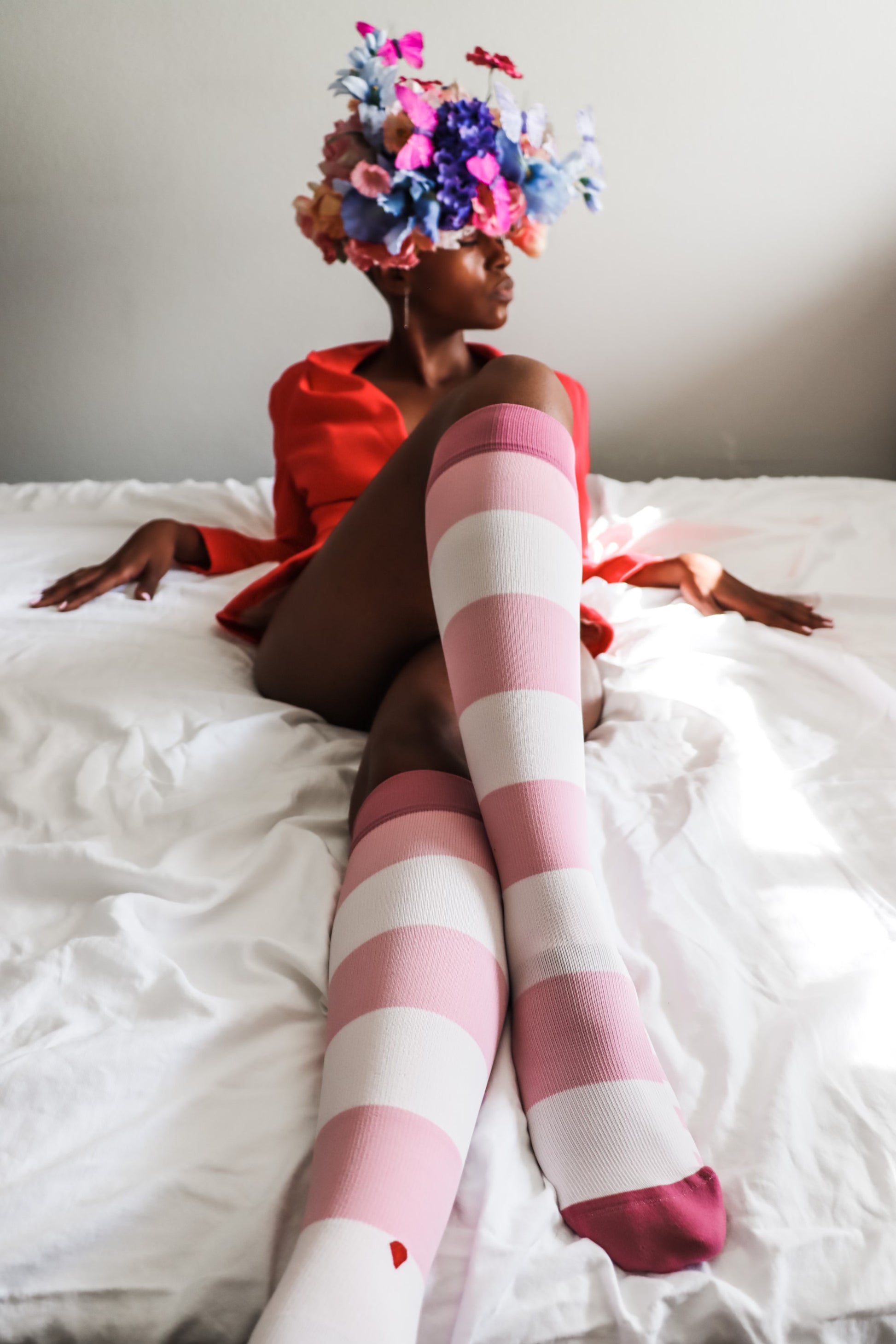 compression socks in varied shades of pink on a beautiful black woman in a floral crown